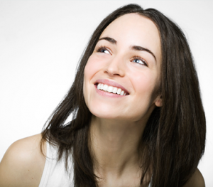 A young woman smiling proudly with recently whitened teeth.