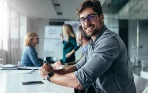 A young man smiling at work, free from worry about dental anxiety thanks to sedation dentistry in Englewood.