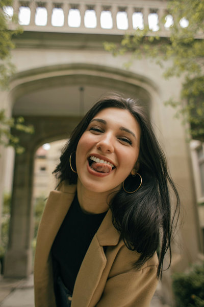 Smiling female dental patient licking front of teeth