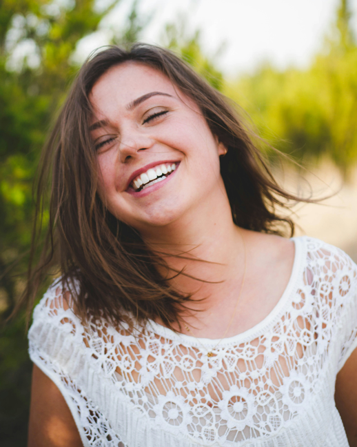 Smiling dental veneers patient in Englewood, OH shows off her straight white teeth outside