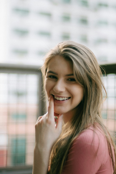 Smiling female gum disease patient in Brookville, OH points to gum line