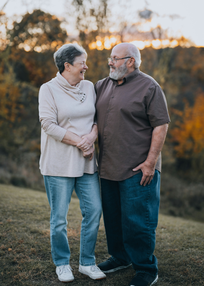 Smiling husband and wife  fixed denture patients smile for a photo outside in Dayton, OH