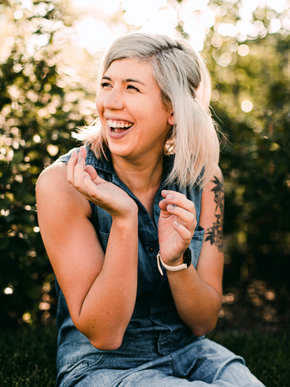 Smiling female dental crowns patient in Dayton, OH sits outside laughing in the sunshine